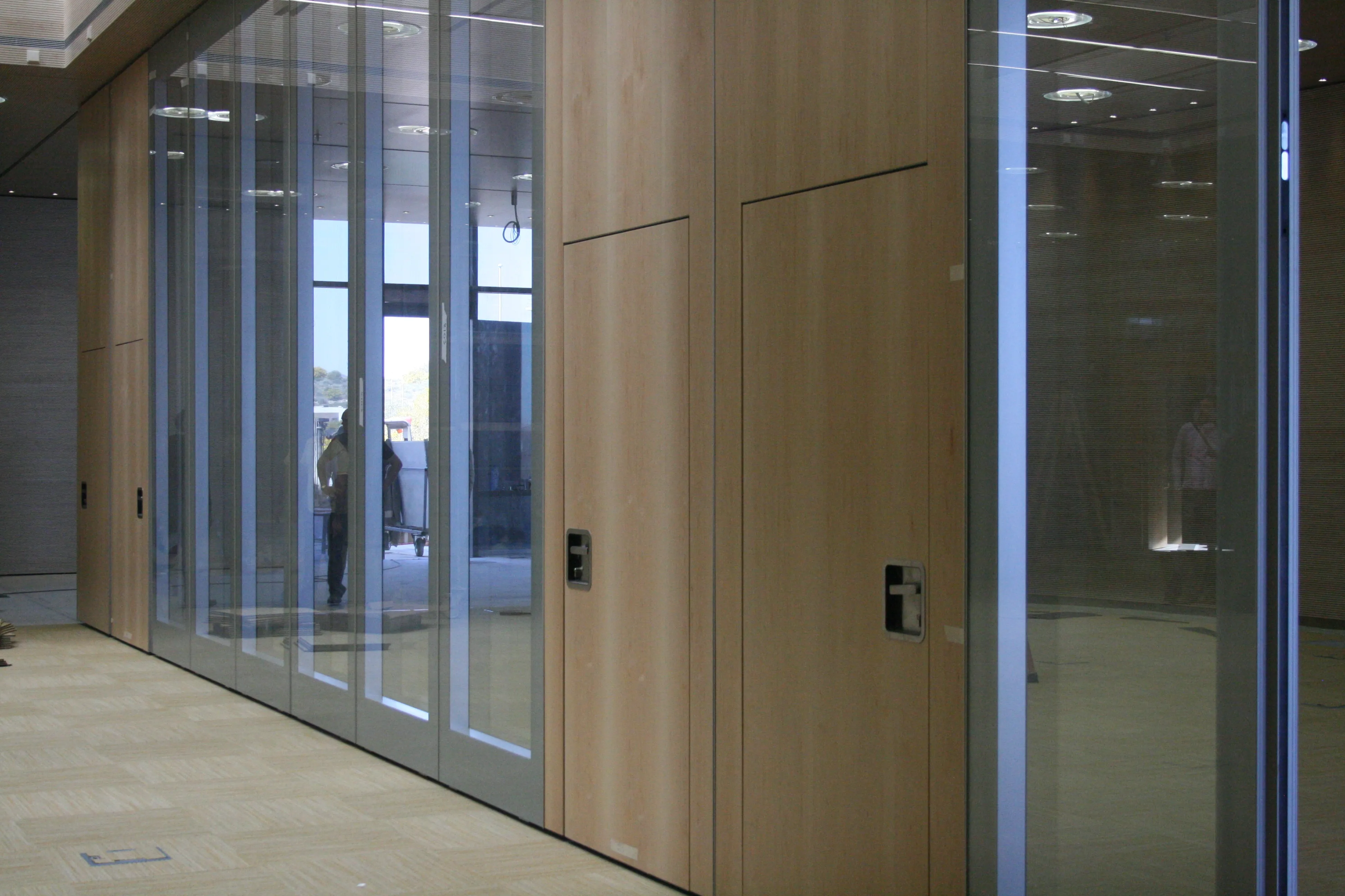 Muro móvil de cristal acústico en entorno corporativo de alto desempeño